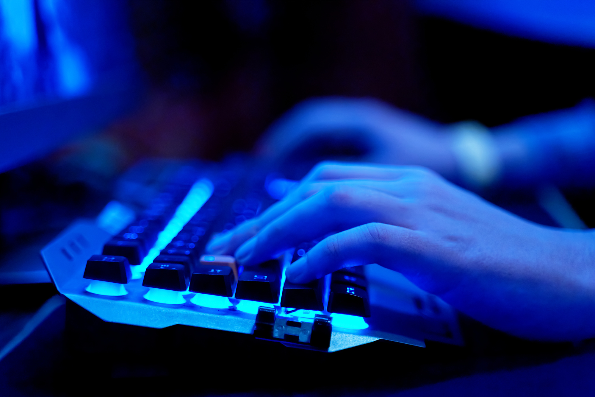 Man playing Gaming Keyboard with blue neon