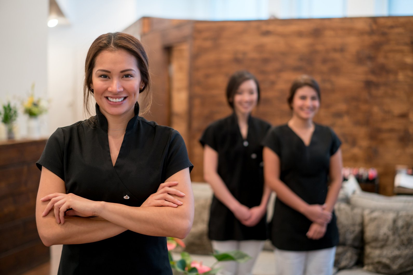 Happy business owner at a spa with a group of workers